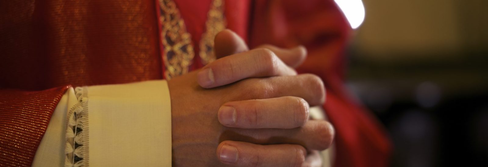 Priester handen gevouwen