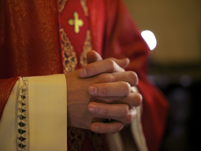 Priester handen gevouwen